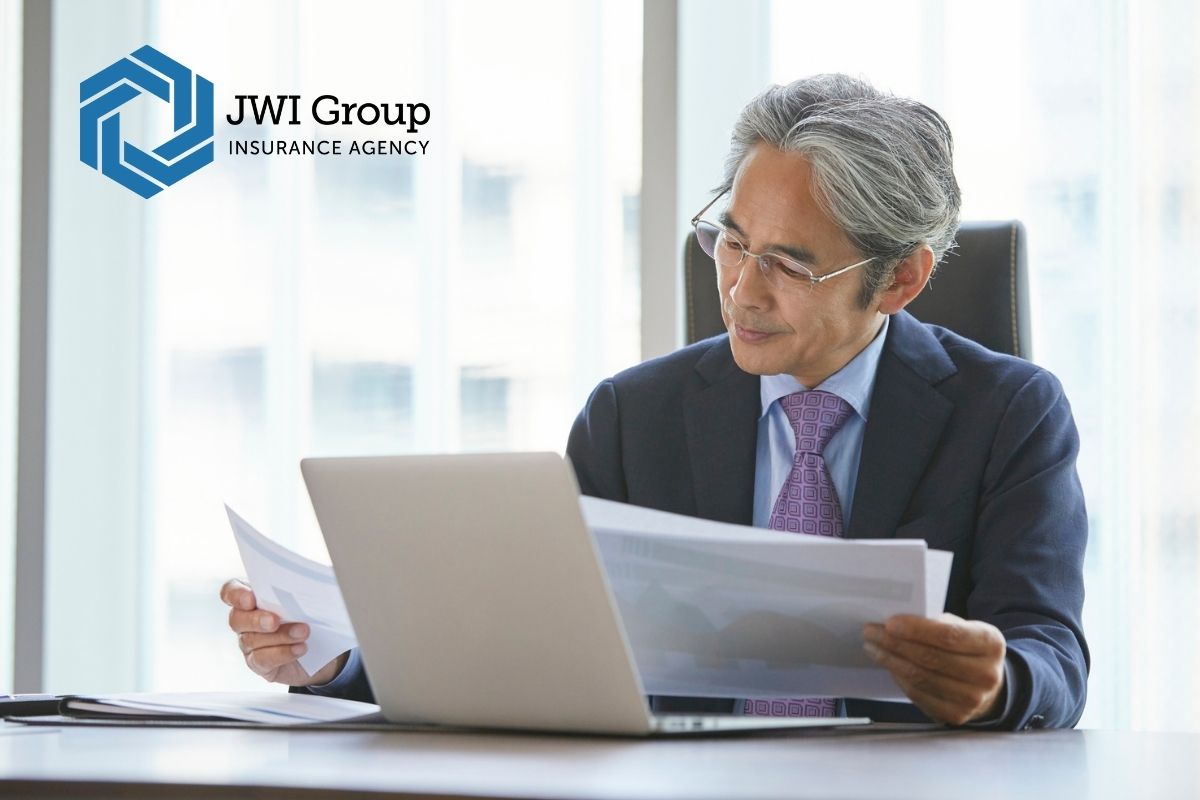 Insurance underwriter reviewing restaurant application documents on laptop, assessing coverage eligibility and risk management.